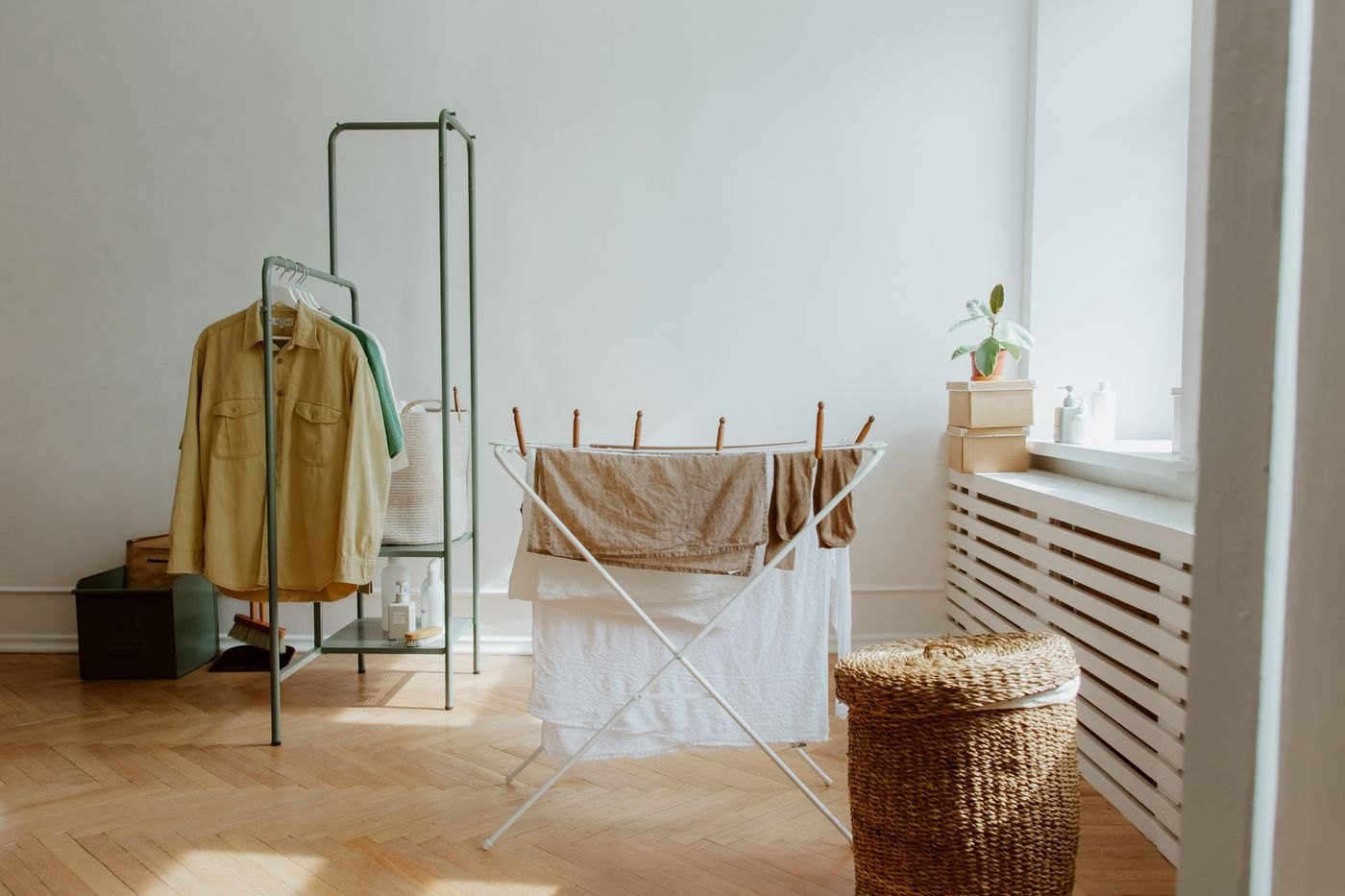 Clothing hanging on a drying rack by a window
