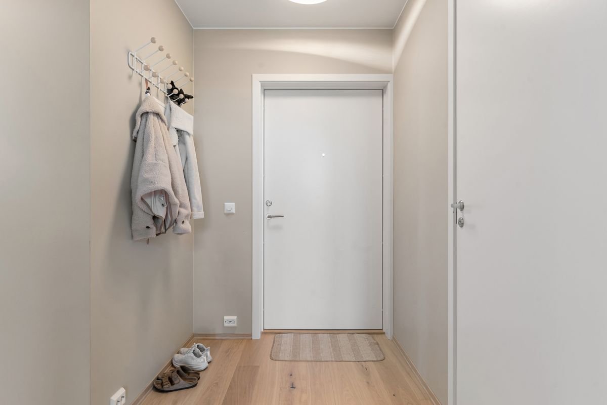 Apartment entrance with wooden flooring and coat hooks