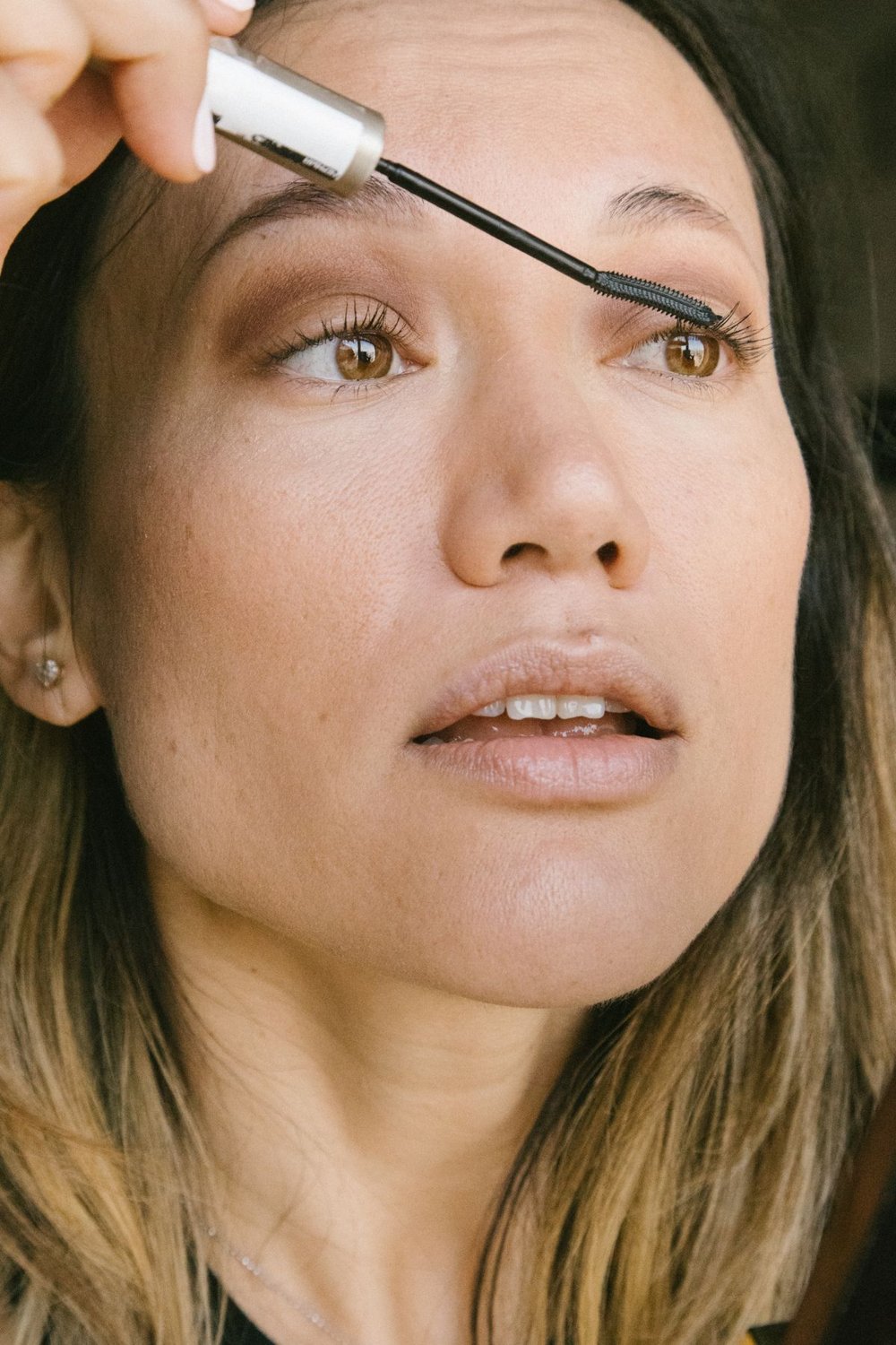 Woman applying mascara to her lashes