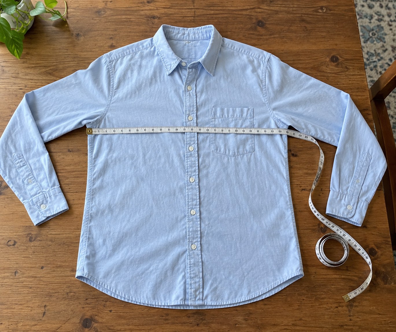 Measuring tape across a shirt laid flat on a table