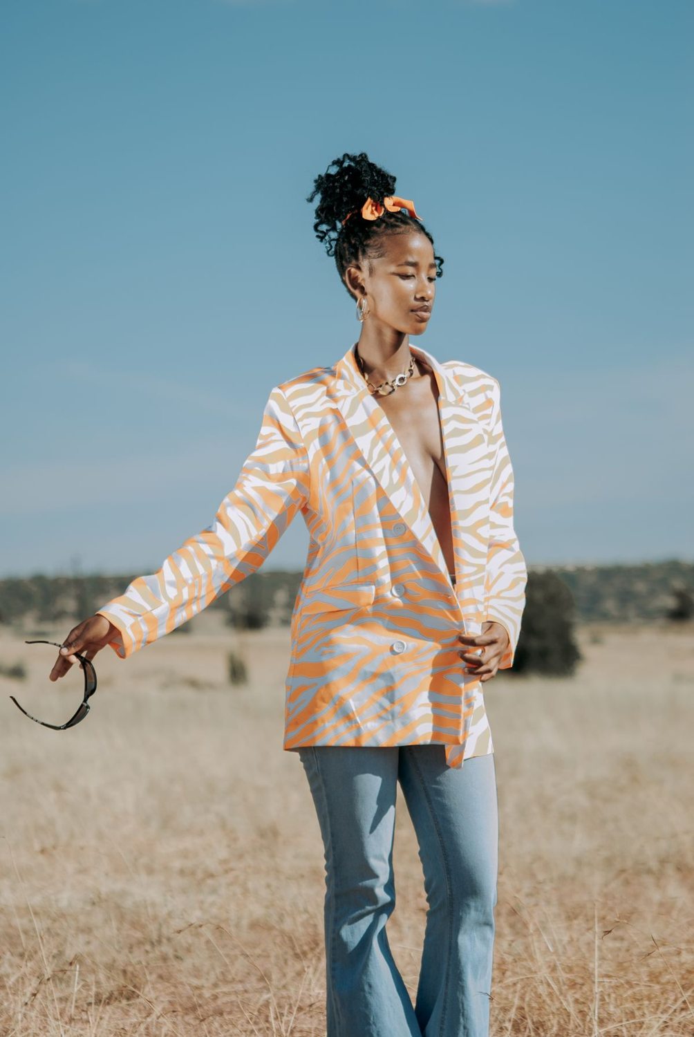 Patterned blazer worn with jeans outdoors