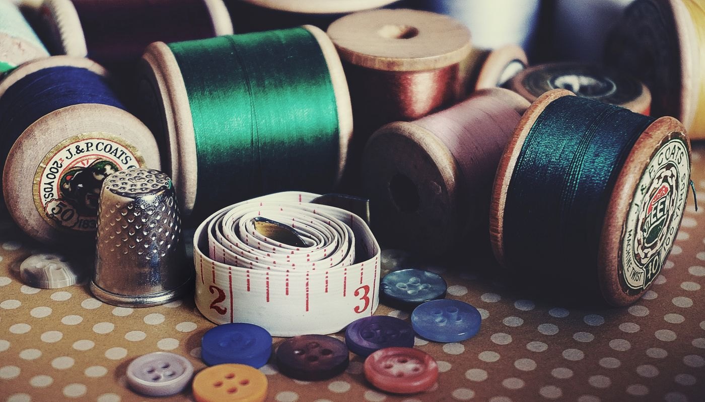 Sewing threads, buttons, measuring tape and a thimble