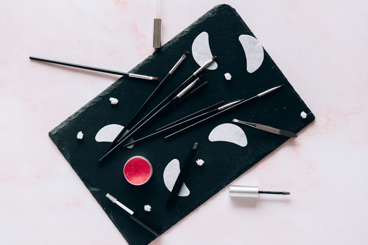 Personal makeup tools arranged on a black tray