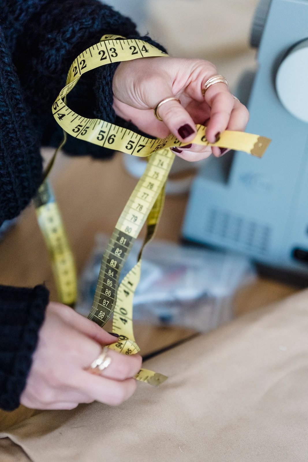 Measuring tape held beside a sewing machine