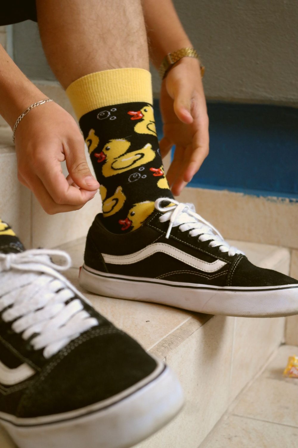 Patterned socks visible above black trainers