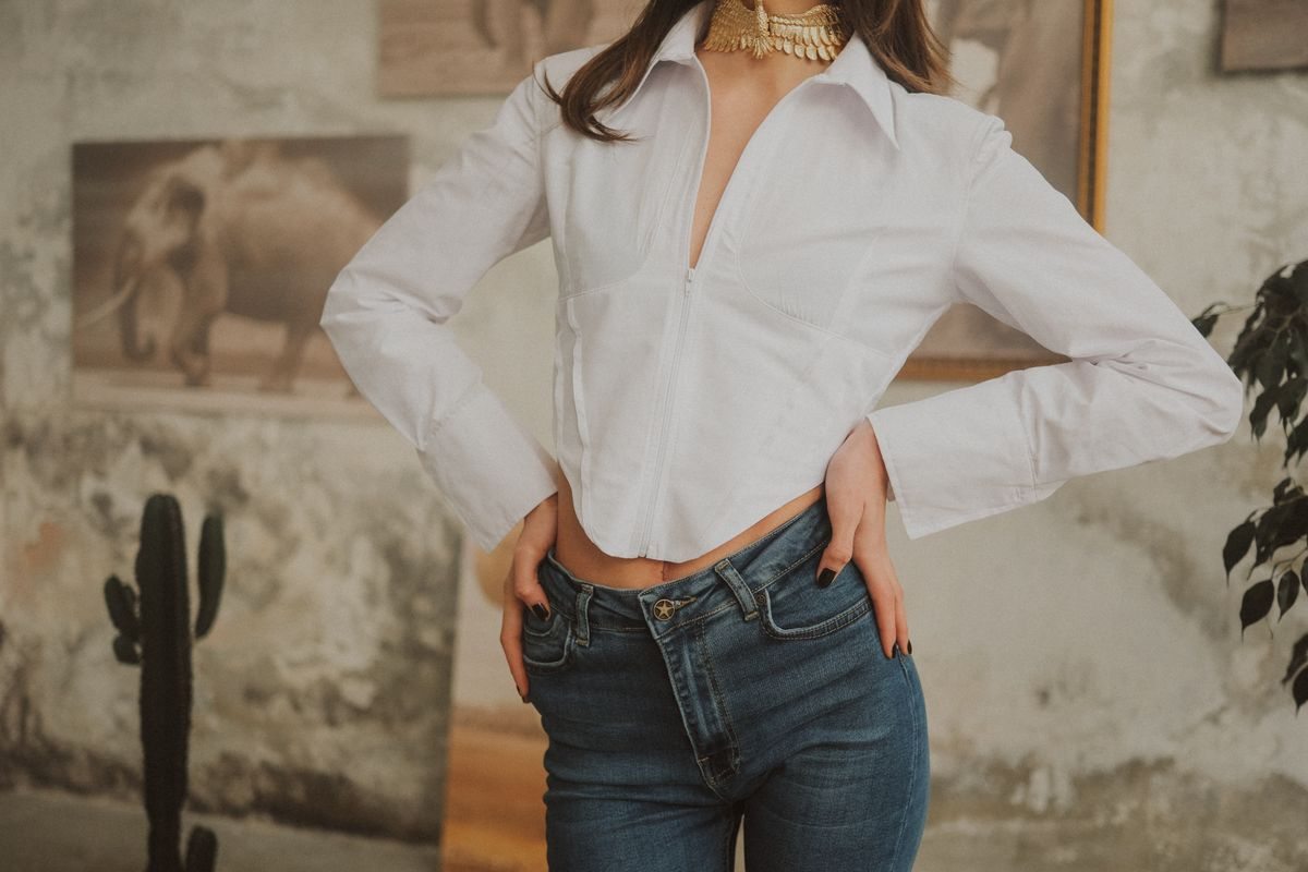 Woman wearing a white shirt with blue jeans indoors