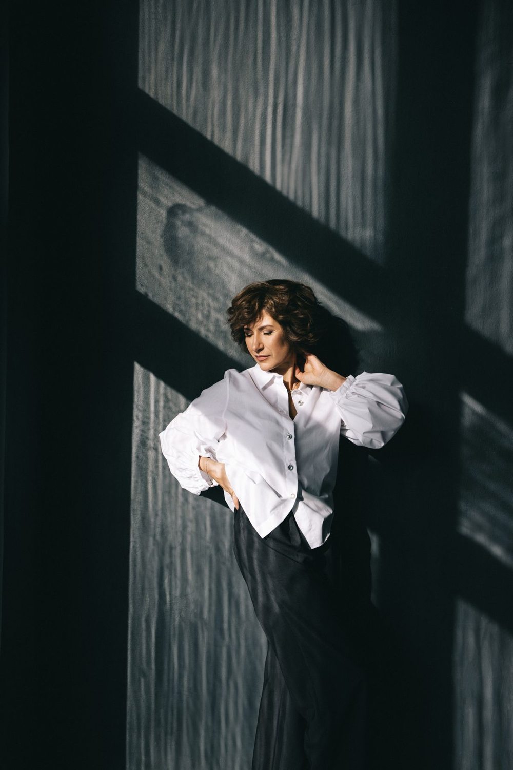 White blouse worn with a dark pleated skirt
