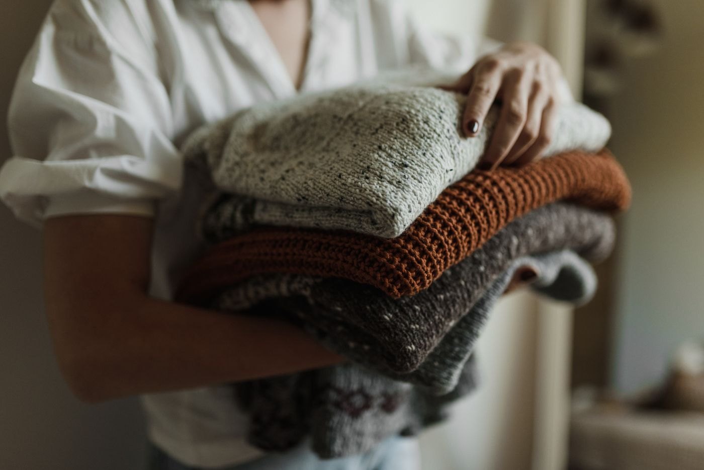 Woman holding folded knitwear