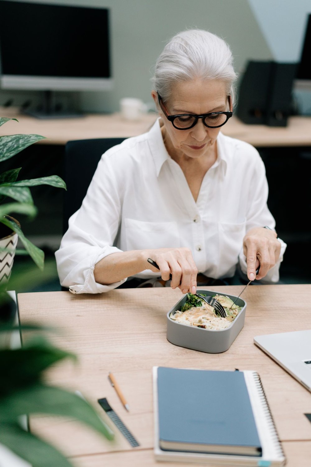 Woman eating a packed lunch at a desk